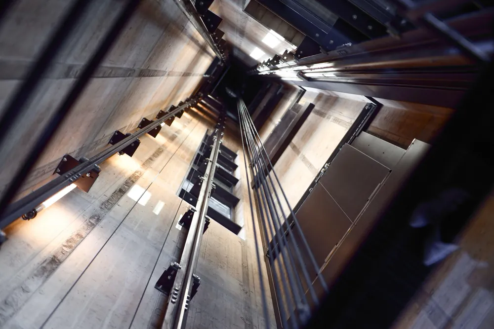 Elevator shaft interior showing rails and cables used for regenerative braking energy recovery